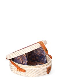 Cesto di paglia intrecciata con accenti in pelle marrone, dotato di un interno a motivo blu. Forma rotonda con un design a coperchio aperto, che mette in mostra materiali testurizzati.