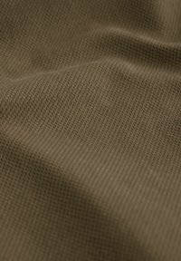Tissu au toucher brun avec un motif fin en quadrillage, affichant une apparence douce et légèrement froissée, adapté à diverses applications.