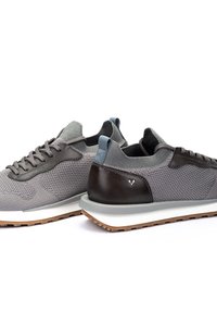 Zapatillas de malla gris con detalles de cuero gris oscuro, superficie texturizada, punta redonda, suela de goma plana y un detalle de marca mínimo en el talón.