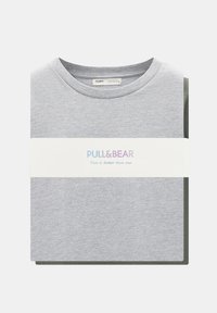 Tricou gri cu guler rotund, având o bandă albă cu „PULL&BEAR” și „Mai bine doi decât unul” în culori pastelate. Material moale din bumbac.