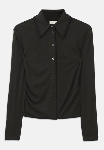 Svart långärmad skjorta med knäppning framtill, stor krage och rynkad textur på sidorna, tillverkad av mjukt tyg.