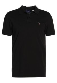 Polo shirt noir à manches courtes avec col et deux boutons, comprenant un petit logo GANT à gauche sur la poitrine.