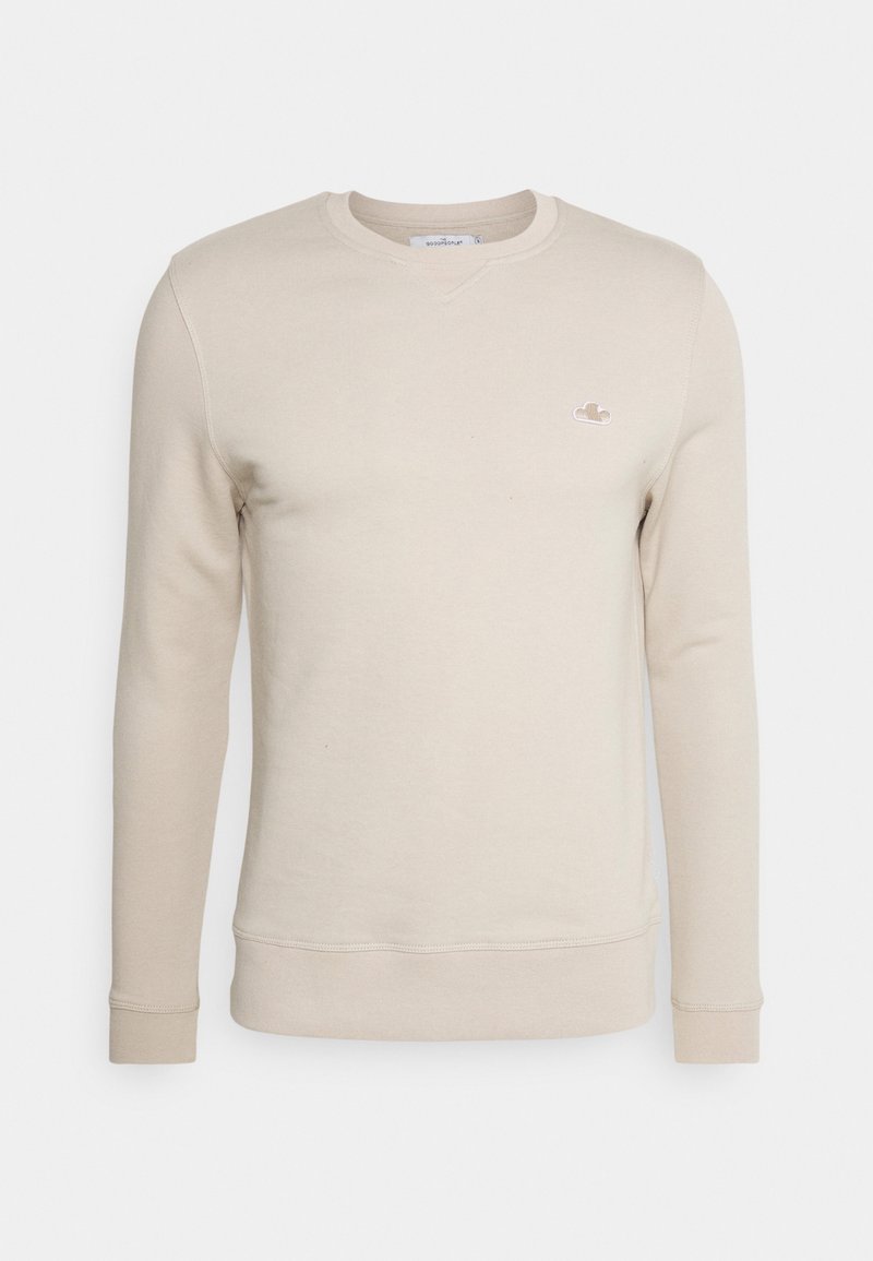Sudadera beige de manga larga, con cuello redondo y un pequeño logo bordado. Confeccionada en un tejido suave, con puños y dobladillo ribeteados.