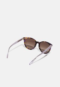 Katzenaugen-Sonnenbrille mit einem mehrfarbigen lila und schwarzen Rahmen, braunem Verlaufsglas und klaren lila Bügeln.