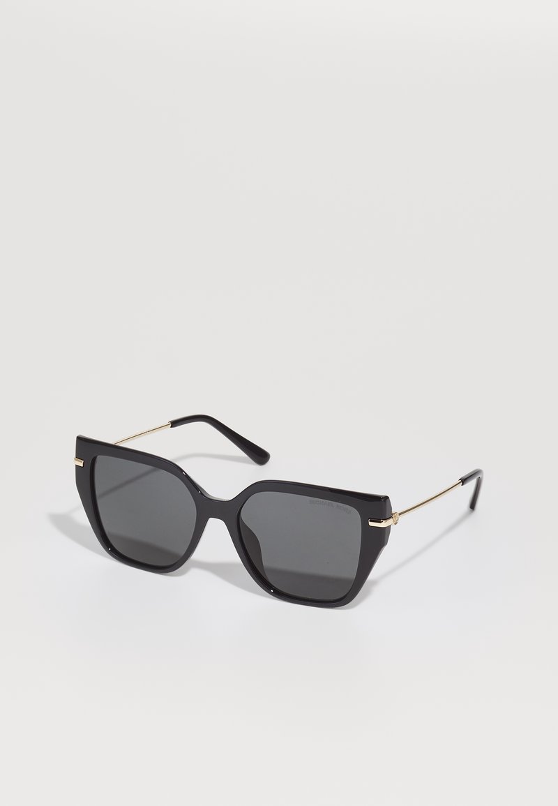 Ochelari de soare supradimensionați, negri, cu lentile întunecate solide, cadru geometric plat, detaliu auriu la tâmplă și brațe negre elegante.