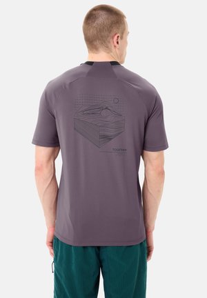 Mann trägt ein lila kurzärmeliges Hemd mit einem topografischen Kartenmuster und dem Wort „TOGETHER“ auf der Rückseite, kombiniert mit türkisfarbenen Hosen.