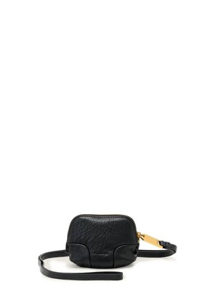 Kleine zwarte crossbodytas van getextureerd leer met gouden ritssluiting en verstelbare band, geplaatst op een witte achtergrond.