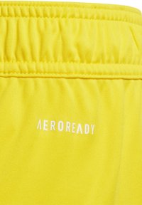 Gele shorts van vochtafvoerend materiaal met een elastische tailleband, met de tekst "AEROREADY" in het wit op de zijkant.