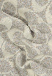 Tecido de malha com uma base creme suave e padrões grandes em cinza claro e bege. A textura é aconchegante e ligeiramente felpuda, com detalhes intrincados.