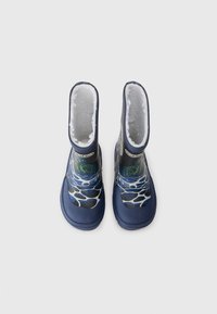 Bottes de pluie en caoutchouc bleu avec un design texturé, dotées d'une doublure blanche en peluche et de motifs aquatiques abstraits dans des teintes de bleu et de vert.