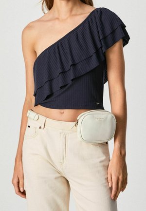 Top corto a costine blu navy con una spalla arricciata, abbinato a pantaloni beige chiaro e una borsa a tracolla color crema chiaro con chiusura a zip.
