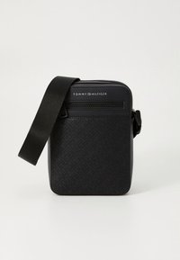 Geantă de umăr neagră Tommy Hilfiger cu model de logo embossat, buzunar frontal cu fermoar și baretă reglabilă pentru umăr.