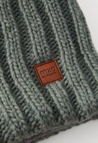Gestrickte Mütze in Grau mit erhabener Rippenstruktur, versehen mit einem braunen Lederpatch mit der Aufschrift "mxl" von maximo.