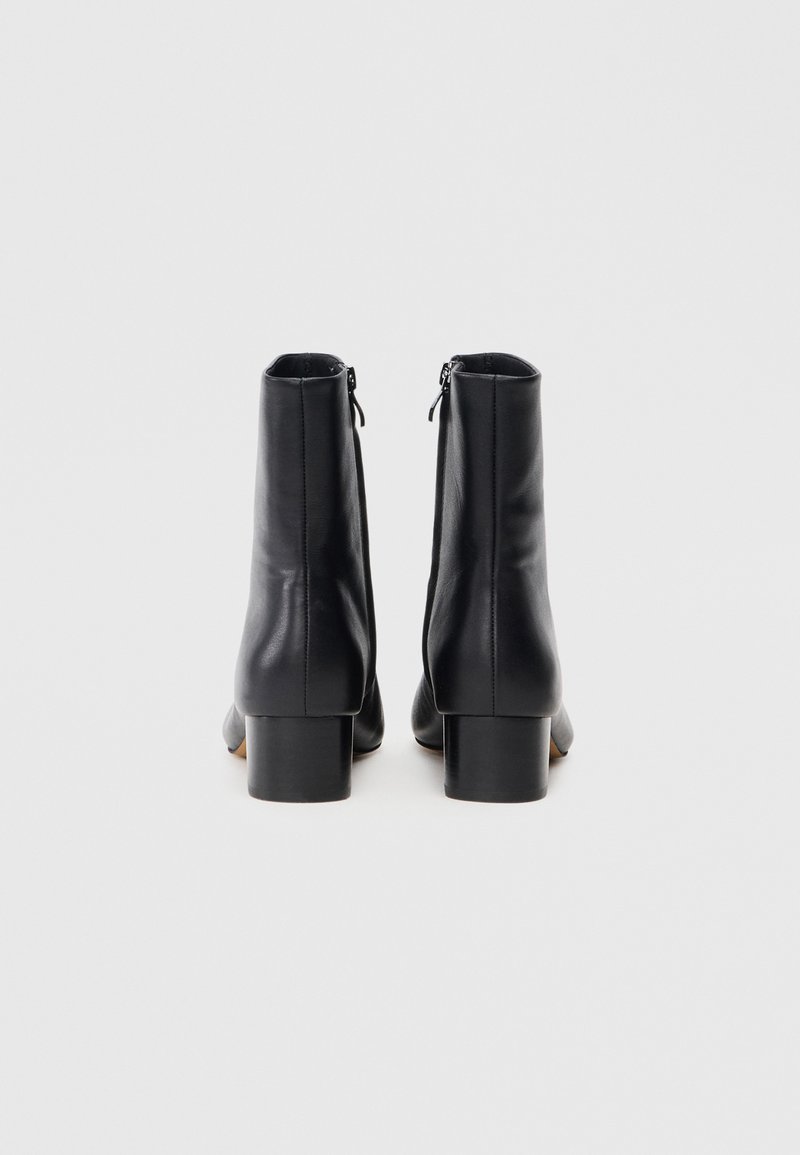 Stivaletti neri in pelle con superficie liscia, chiusura a zip sul retro e tacco quadrato.