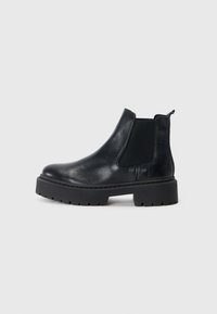 Botas Chelsea de cuero negro con paneles elásticos en los laterales y una suela de goma gruesa. Textura suave con punta redondeada y tira en la parte trasera.