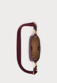 Burgundijas krūšu soma ar teksturētu ārpusi, zelta aksesuāriem un rakstainu siksnu. Atvērta virsma atklāj bēšu krāsas oderi.