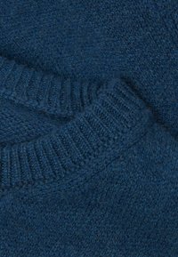 Donkerblauwe gebreide trui met een gestructureerde, zachte stof en geribde manchetten. Het ontwerp heeft een ronde hals en naadloze afwerking.