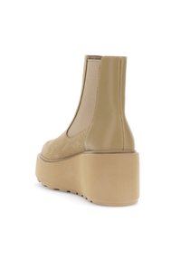 Bottine Chelsea plateforme beige avec devant en suède, dos en cuir lisse, panneau latéral élastique et semelle en caoutchouc épaisse, vue en angle pour montrer l'arrière et le côté.