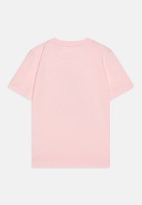 T-shirt en coton rose clair avec des manches courtes, un col rond et un dos uni, offrant une texture douce et une coupe standard.