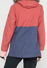 Kurtka w blokach kolorystycznych z koralowo-różową górą, granatowym pasem w środkowej części i jasnoróżowymi rękawami. Kaptur z futrzanym wykończeniem i detalem z logo.
