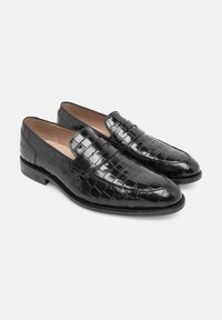 Schwarze Slipper aus glänzendem Leder mit einem Krokodilsledermuster. Sie verfügen über eine abgerundete Spitze und einen niedrigen Absatz für zusätzlichen Komfort.