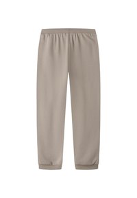 Beige mjukisbyxor med elastisk midja, smalnande ben och åtsittande muddar. Gjorda av mjukt tyg med en slät textur.