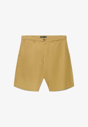 Short beige pour homme longueur genou avec passants de ceinture, poches latérales, fermeture par boutons et étiquette de marque visible à l'intérieur de la taille.