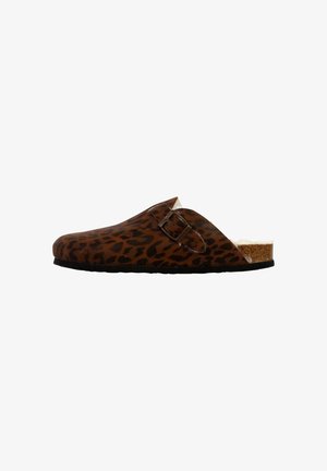 Klovens met luipaardprint zijn slip-ons en hebben een kurken voetbed en een decoratieve gesp. Bruine tinten met zwarte accenten op het bovenste oppervlak.