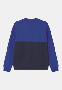 Sinine ja tumesinine värviplokkidega suder, millel on pikad varrukad, ümar kaelus ja pehme, tekstuuriga kangas. Sirge ääreline ribadega mansetid.