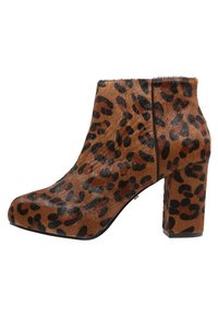 Kengät nilkkureissa leopardo-kuosisella painatuksella, ruskean ja mustan turkin kaltaisella tekstuurilla, paksulla korolla ja pyöristetyllä varpaanmuodolla, korostaen rohkeita eläinkuosseja.