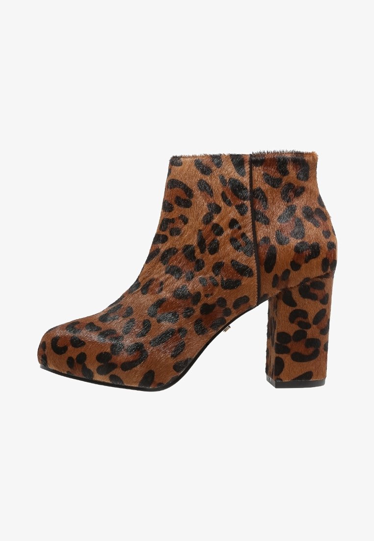 Kengät nilkkureissa leopardo-kuosisella painatuksella, ruskean ja mustan turkin kaltaisella tekstuurilla, paksulla korolla ja pyöristetyllä varpaanmuodolla, korostaen rohkeita eläinkuosseja.