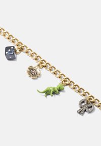 Bracciale in oro con un dado nero, un ciondolo a forma di dinosauro verde, un ciondolo floreale e un simbolo decorativo di colore argento.
