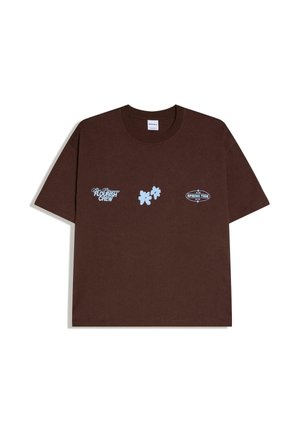 Brown short-sleeve T-shirt with light blue designs: "Flourish Crew" text, three leaf graphics, and oval "Spring Tide 2018" logo.