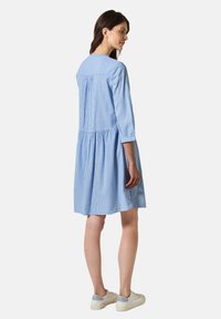Abito a righe blu e bianche con maniche a tre quarti, vita arricciata e vestibilità comoda, realizzato in un tessuto leggero.