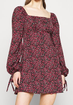 Vestido negro con flores y mangas largas abullonadas, con escote cuadrado. El estampado incluye flores rosas y blancas. Cintas laterales en las mangas.