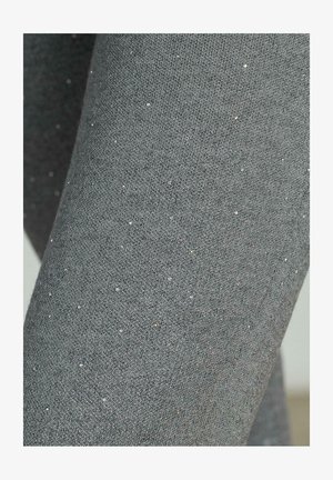 Leggings grigi realizzati in materiale morbido con una superficie testurizzata, caratterizzati da piccole particelle metalliche distribuite uniformemente.