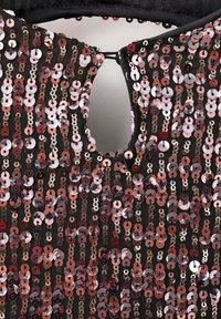 Čierny odev s výstrihom v tvare kľúčovej dierky, ozdobený ružovo-zlatými a striebornými flitrami usporiadanými vertikálne v líniách.