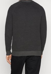 Dark gray knitted sweater with textured pattern, ribbed collar, cuffs, and hem. Shows back view with solid-color finish and long sleeves.