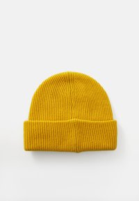 Căciulă tricotată ribbed de un galben aprins, cu margine pliată, așezată plat pe un fundal alb.
