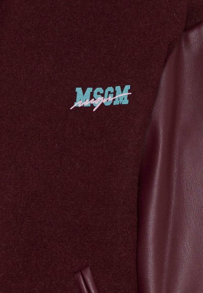 Giacca bordeaux con una texture simile alla lana. Il lato sinistro presenta un logo "MSGM" in teal e rosa con un design stilizzato. Il lato destro ha una finitura in pelle liscia.