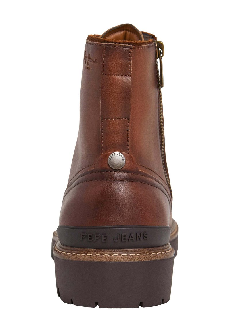 Botín de ante marrón con acabado texturizado, cremallera lateral y cuello acolchado. Presenta una suela de goma y un logotipo en relieve de "Pepe Jeans".