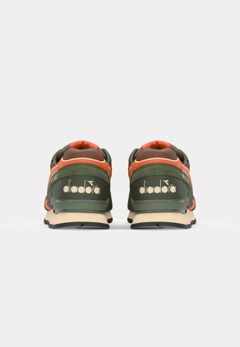 Grüne und orange Sport Schuhe aus Mesh- und Wildledermaterialien, mit einer beigen Sohle und auffälligem goldfarbenem Branding an der Ferse.