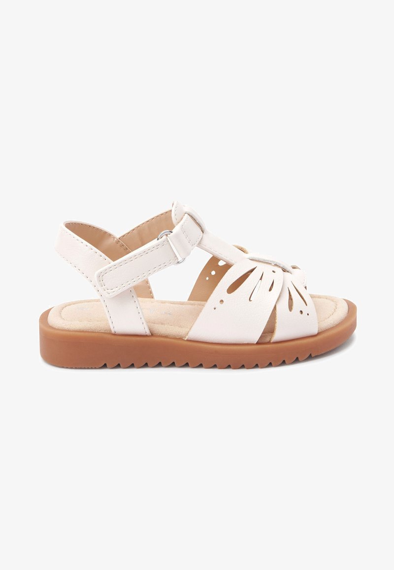 Sandal in pelle bianca con design floreale a intaglio, cinturino alla caviglia regolabile, soletta imbottita e suola in gomma marrone testurizzata per grip.