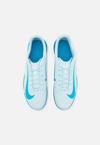 Pár světle modrých sportovních bot s modrými značkami Nike swoosh, zobrazených shora na bílém pozadí.