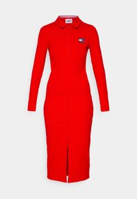 Robe longue rouge à manches longues avec une silhouette ajustée, fermeture éclair à l'avant, col et détail logo sur la poitrine gauche.