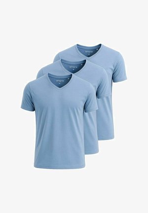Lys blå v-hals t-shirt parret med cremefarvede cargo bukser. Tekstureret stof og side lommer, suppleret med beige sneakers.