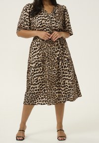 Kleid mit Leopardenmuster, V-Ausschnitt, kurzen Ärmeln und tailliertem Bund. Hergestellt aus leichtem Stoff, verfügt es über einen knielangen Rock und Knöpfe.