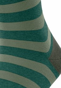 Grüne und beiger gestreifte Socken mit einer glatten Textur, die ein markantes Design und eine verstärkte Ferse in einem dunkleren Farbton aufweisen.