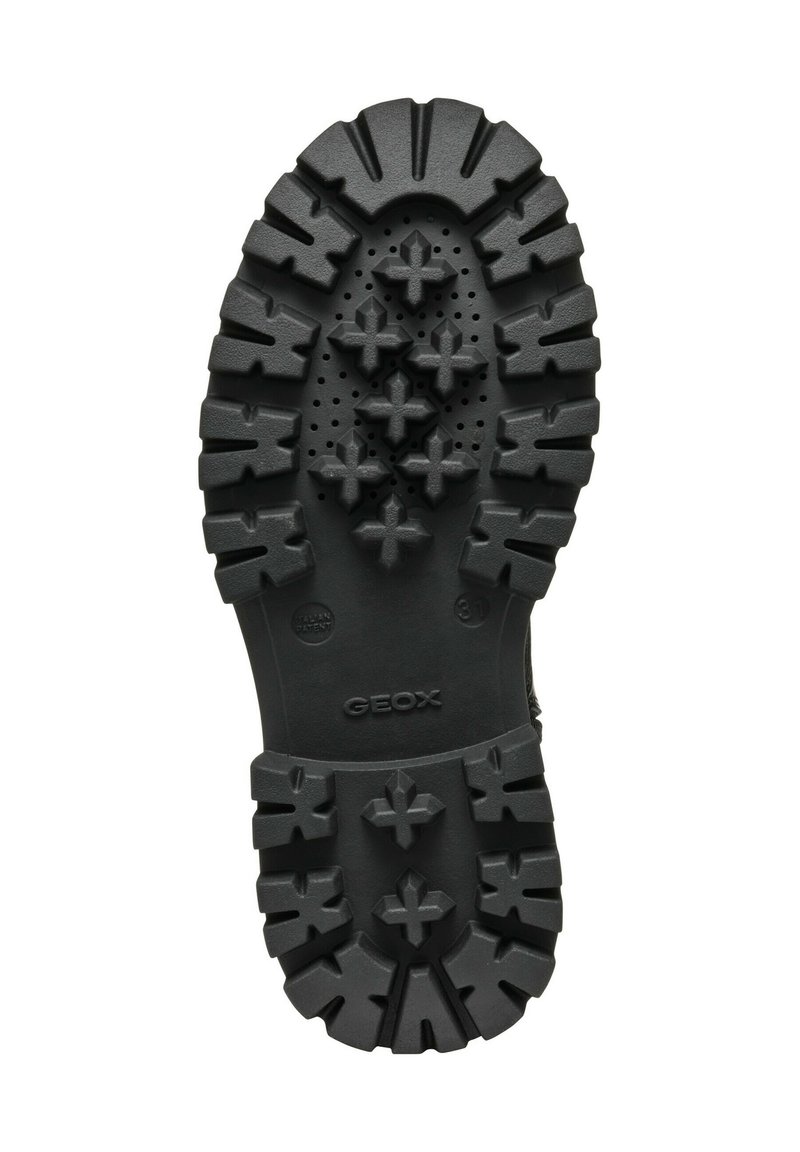 Suola di scarpa in gomma nera con un motivo di battistrada robusto caratterizzato da tasselli a forma di stella e fori di drenaggio; logo del marchio in rilievo visibile.