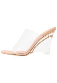 Klart kilklackar med en genomskinlig plastöverdel och en nude-färgad fotbädd; har en slät yta och en elegant krökt design.